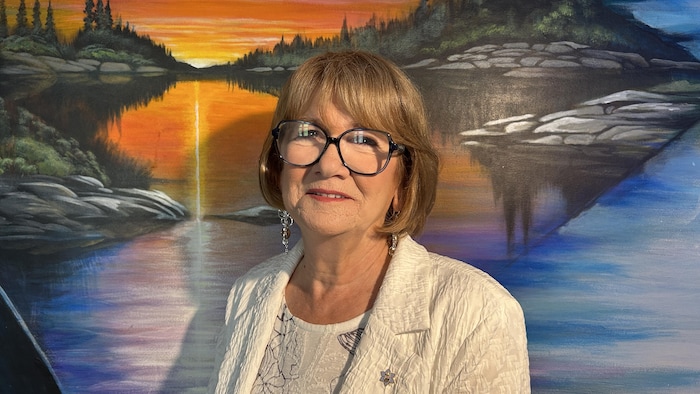 Marion Willis devant une peinture autochtone.