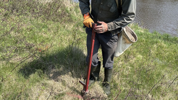 Un homme effectue un marquage sur un terrain.