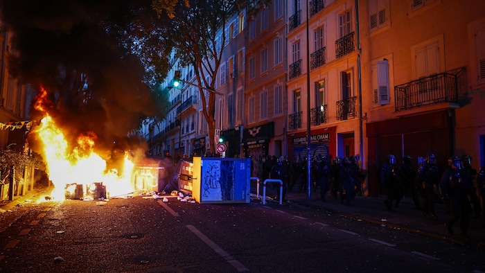 Des agents de la police antiémeute française passent devant une barricade en feu lors d’une manifestation