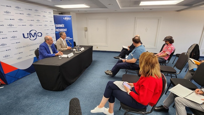 The two men sat at a press conference in front of reporters in a small room.