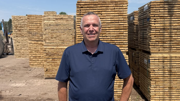 Martin Lavoie devant des palettes de bois.
