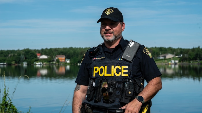 Un agent de la Police provinciale de l'Ontario pose pour une photo dehors, devant le lac Whitewater, à Azilda.