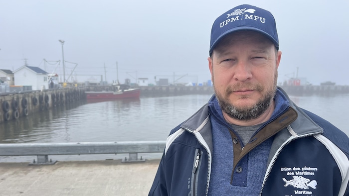Un homme souriant à la caméra, sur un quai de la Péninsule acadienne.