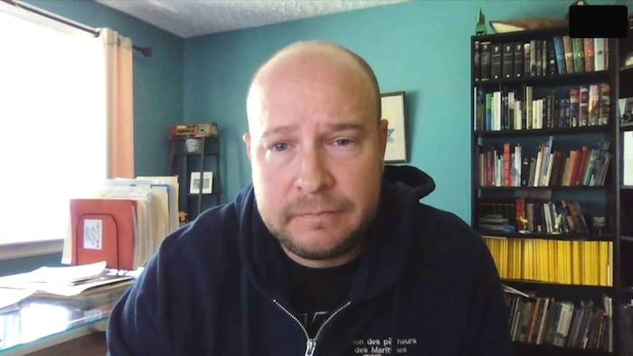 Martin Mallet en entrevue par webcam. Il est assis dans un bureau.