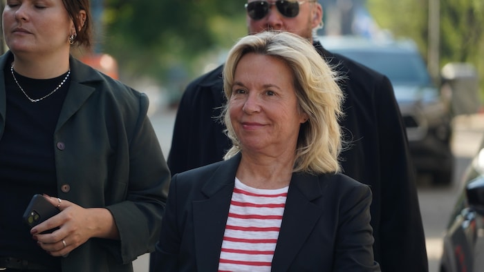 Martine Biron, l'air satisfaite, marche dehors.