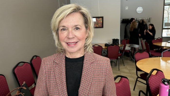 La ministre sourit à la caméra.