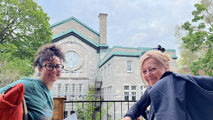 Cindy Bertran Cerino et Caroline Tétrault, souriantes, devant la cheminée d'une église.