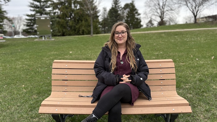 Mary-Pier Lampron-Drolet assise sur un banc de parc. 
