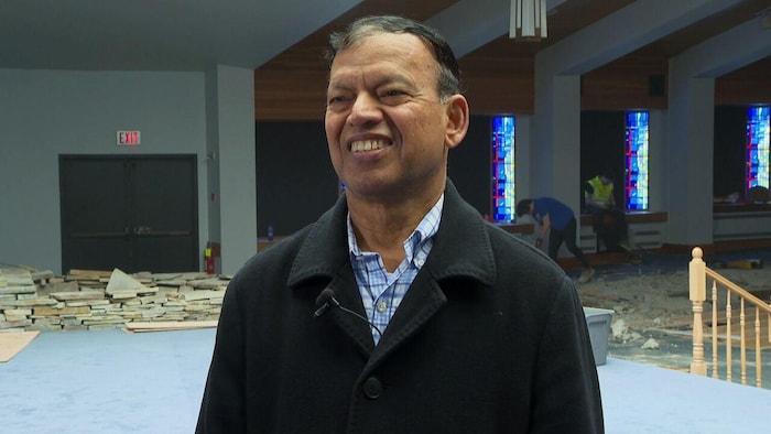 Haseen Khan, souriant, dans une mosquée en construction. 