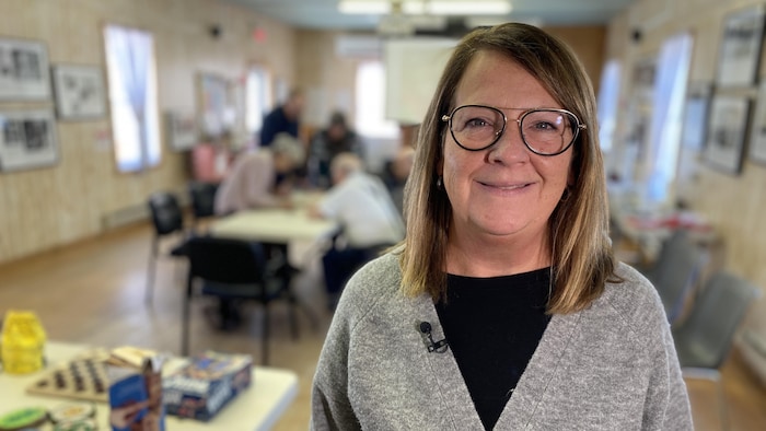 Maryse Plouffe sourit dans la salle du centre de jour.