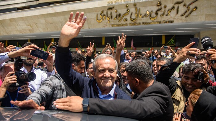 Aday Masoud Beseshkian, İran cumhurbaşkanlığı seçimi için sandık başına gittikten sonra kalabalığı selamlıyor. 