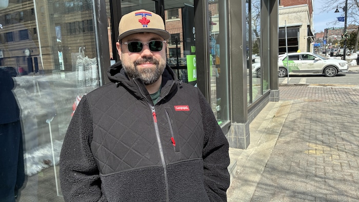 Une personne avec une casquette et un manteau, dehors.
