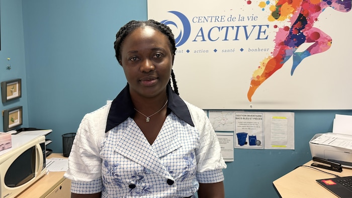 Eby-Ama Koua pose dans un bureau.
