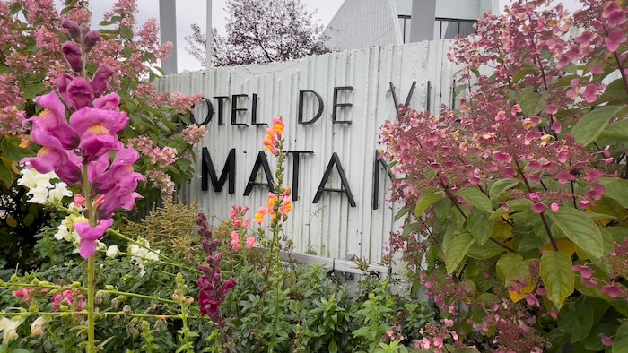 Des fleurs devant l'enseigne de l'Hôtel de ville de Matane.