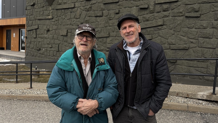 Deux hommes posent devant un hôtel de Matane.