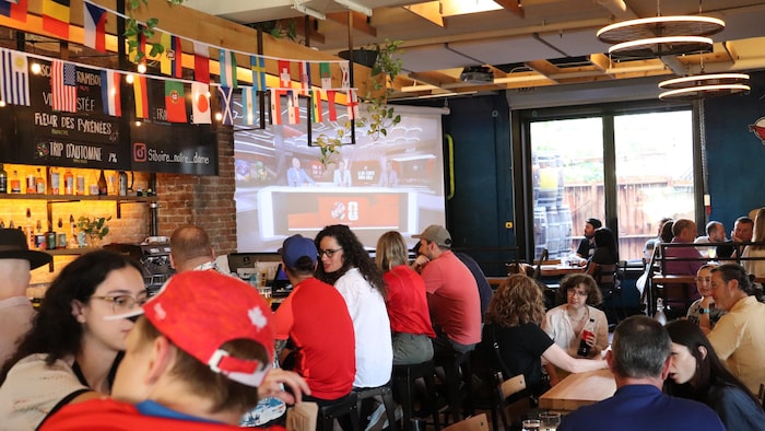 Des personnes regardent un match dans un bar.