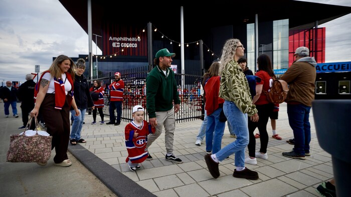 Un très jeune enfant marche avec une suce et un chandail du Canadien pour se rendre à l'Amphithéâtre.