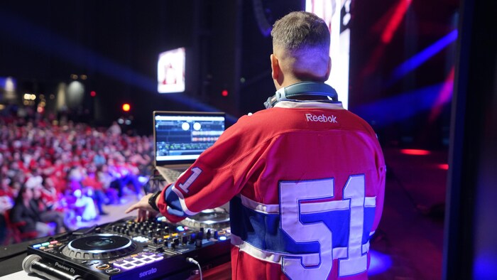 Un DJ met de la musique devant une foule.