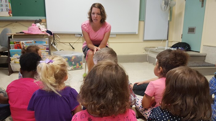 Une enseignante discute avec des enfants dans une classe de maternelle.