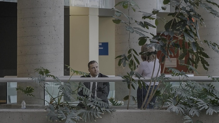 Mathieu Gingras, assis sur un banc du palais de justice de Québec en train d'échanger avec la journaliste Maude Montembeault.
