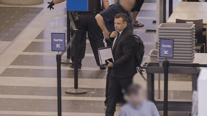 Mathieu Gingras, habillé en complet noir, se déplaçant au palais de justice.