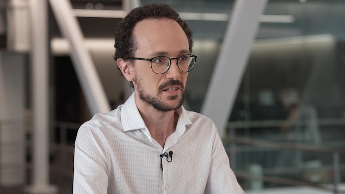 Un homme parle à la caméra.