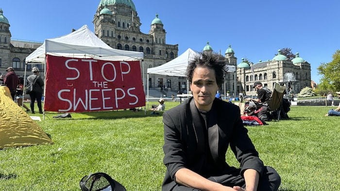 Mathieu Pacheco Ramirez, assis sur la pelouse devant l'Assemblée législative, à Victoria, le 8 mai 2024.