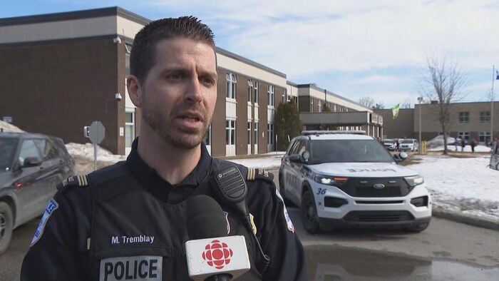  Mathieu Tremblay devant une école. 