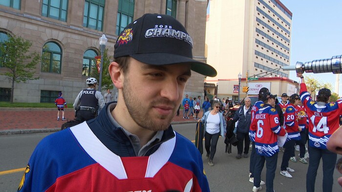 Mathis Rousseau interviewé devant d'autres joueurs dans la rue.