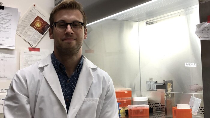 Matt Anderson-Baron est vêtu d'un sarrau, assis dans son laboratoire.