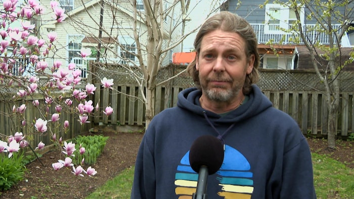 Une homme interviewé à l'extérieur.