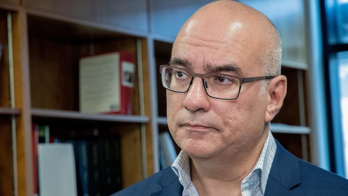 Le Dr Matthew Bowes devant une étagère remplie de livres.