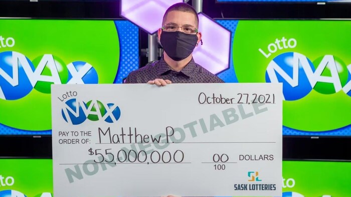 Matthew Poppel avec un chèque géant.