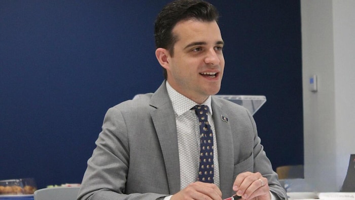 Le maire Matthew Shoemaker assis à une table prend la parole dans le cadre d'un événement public.