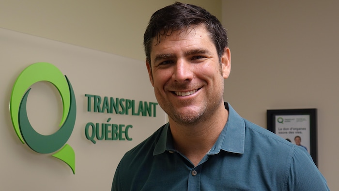 Matthew Weiss devant un logo de Transplant Québec.