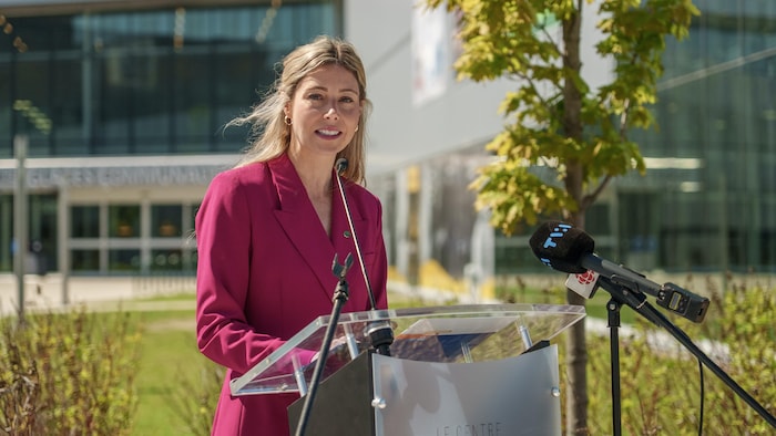 Maude Marquis-Bissonnette ,vêtue de rose, lors d'une conférence de presse à l'extérieur du Centre Slush Puppie.