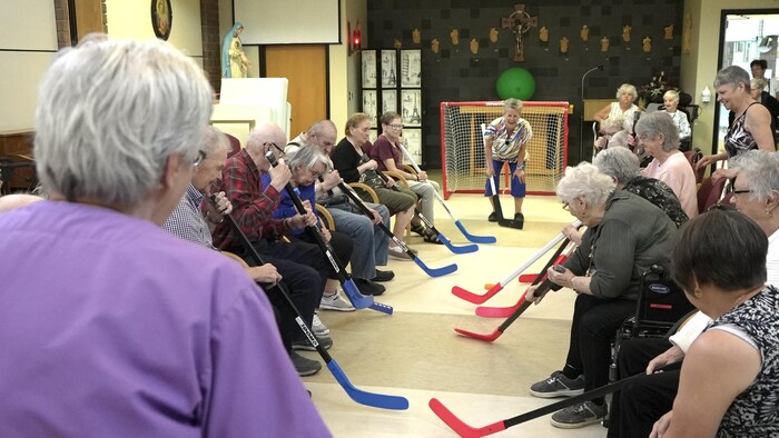 Des aînés jouent au hockey.