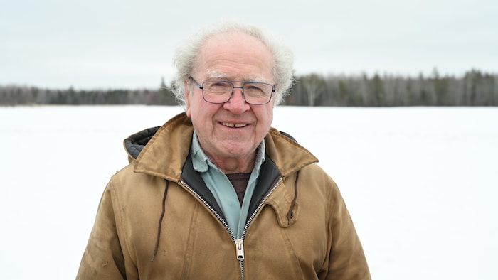Maurice Girouard devant un champ enneigé. 