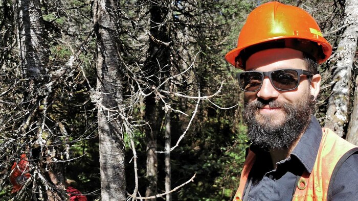 Un homme avec un casque de chantier dans la forêt