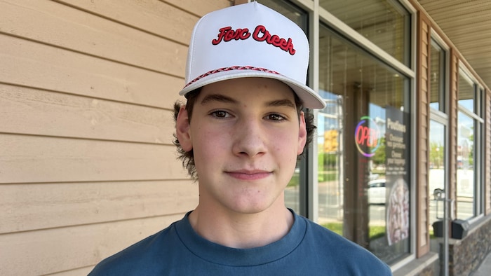 Un adolescent devant un mur extérieur de restauration rapide.
