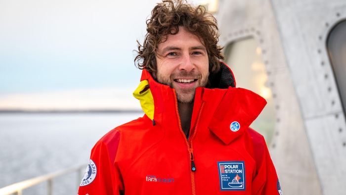 Un homme portant un manteau rouge à bord d'un bateau.
