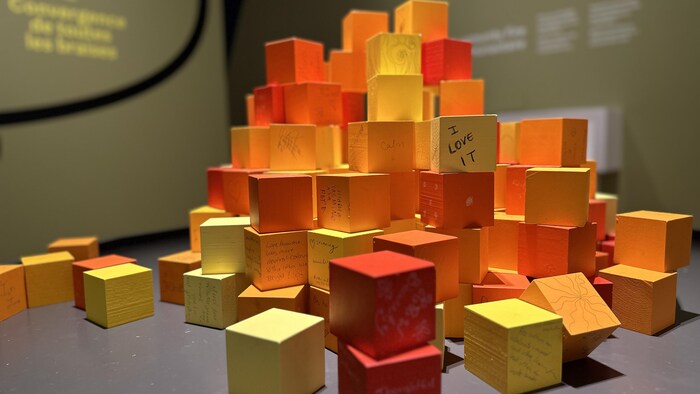 Des blocs de bois orange, jaunes et rouges sont empilés determination ressembler à un feu de camp.