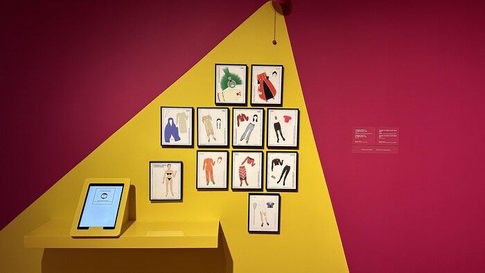 Onze dessins de différentes tenues sont accrochés au mur.