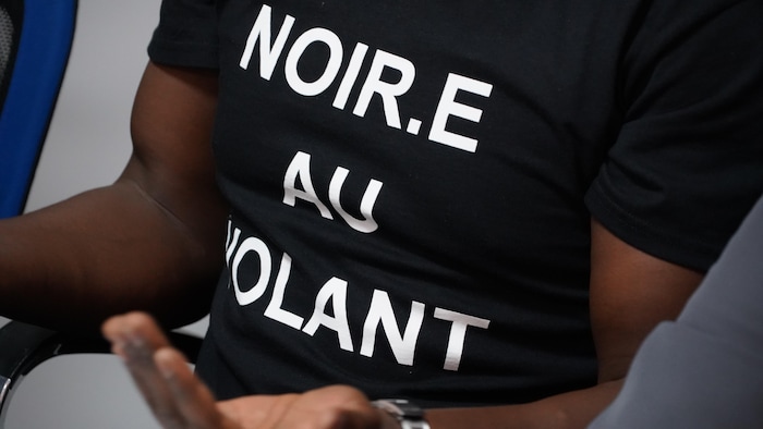 Le t-shirt de Mbaï-hadji Mbaïrewaye où il est écrit noir.e au volant.