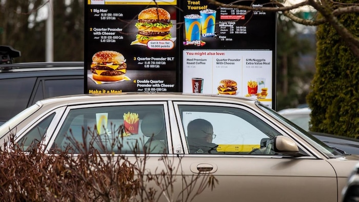 Une personne commande à manger au service au volant d'un McDonald's.