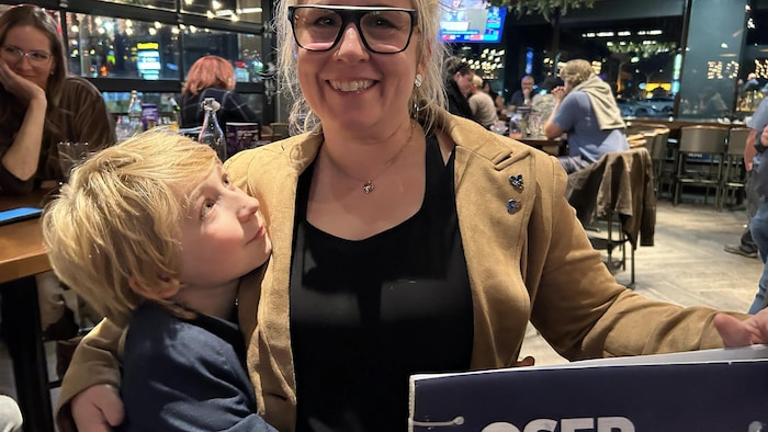 Une femme souriante avec un jeune garçon qui la regarde