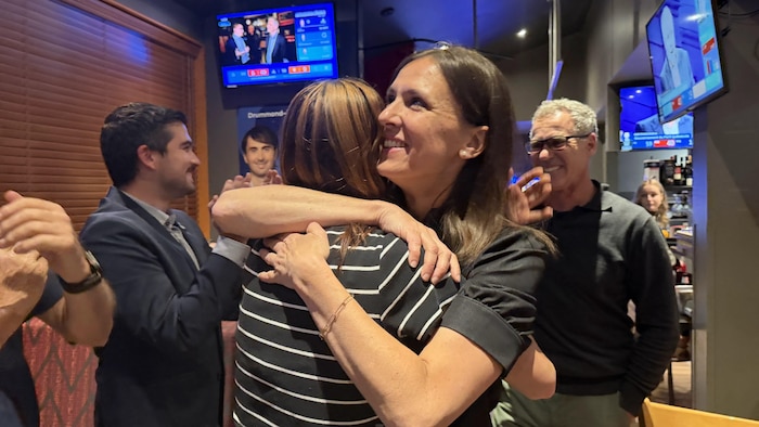 Une femme souriante en enlace une autre