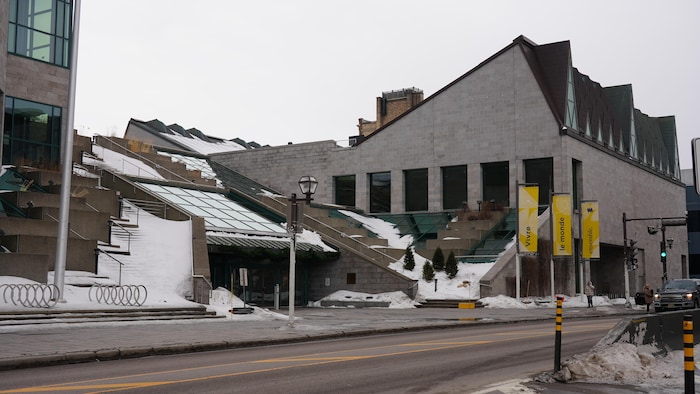 Façade d'un bâtiment de pierre enneigé. 