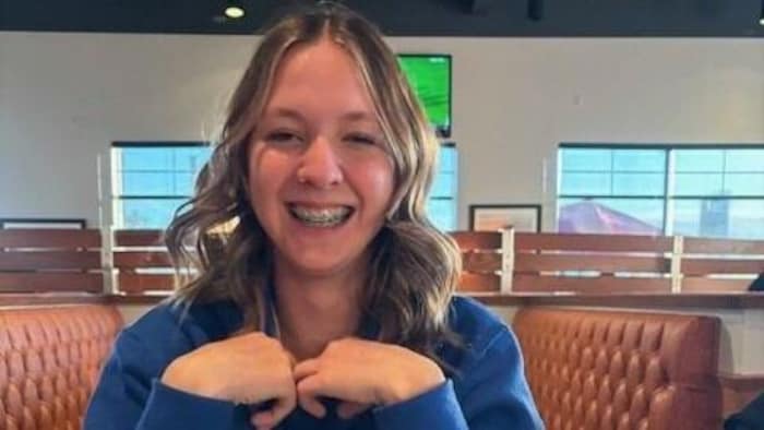 Une jeune fille est assise à la table d'un restaurant.