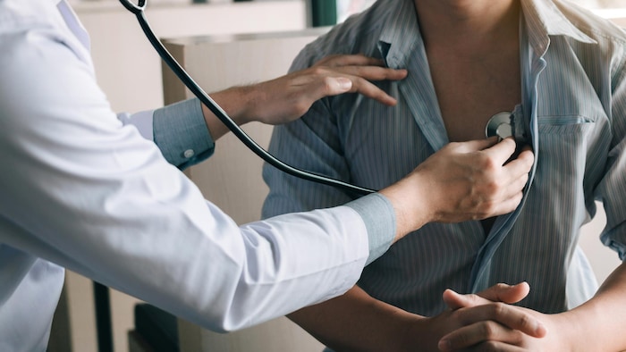 Un médecin utilise un stéthoscope pour écouter le rythme cardiaque d'un patient.
